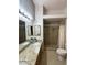 Well-lit bathroom features a double vanity, granite countertops, and a tiled walk-in shower at 4484 Warbonnet Way, Las Vegas, NV 89147
