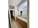 Main bathroom with double sinks, granite countertops, tile floors, and linen closet at 4484 Warbonnet Way, Las Vegas, NV 89147