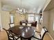 Open-concept living/dining room features hardwood floors, chandelier, and views to fireplace and rear patio at 4484 Warbonnet Way, Las Vegas, NV 89147