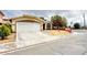 Single-story home boasting a spacious driveway, two-car garage, and well-kept landscaping at 4484 Warbonnet Way, Las Vegas, NV 89147