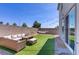 Cozy backyard featuring patio furniture, artificial grass, gravel, and string lights at 5692 Tinar St, Las Vegas, NV 89113