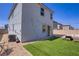 Backyard featuring outdoor furniture, artificial grass, rock landscaping, and string lights at 5692 Tinar St, Las Vegas, NV 89113