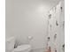 Clean, white bathroom features toilet, toilet paper holder, and a mermaid shower curtain at 5692 Tinar St, Las Vegas, NV 89113