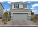 Inviting two-story home features a gray exterior, tiled roof, and two-car garage at 5692 Tinar St, Las Vegas, NV 89113