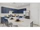 Bright, modern kitchen with blue cabinets, stainless steel appliances, and island seating at 5692 Tinar St, Las Vegas, NV 89113