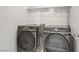 Laundry room with a modern washer and dryer, and a shelf for supplies at 5692 Tinar St, Las Vegas, NV 89113