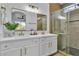 Modern bathroom featuring a double vanity with marble countertop and a sleek glass-enclosed shower at 10200 Wood Work Ln, Las Vegas, NV 89135