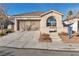 Single-story home with desert landscaping, arched window, and attached garage at 10200 Wood Work Ln, Las Vegas, NV 89135