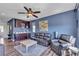Inviting living room with wood laminate floors, comfortable leather sofa, and a wet bar with dark wood cabinets at 10412 Deer Heights St, Las Vegas, NV 89178