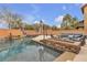 A gorgeous pool with a built-in fire pit and outdoor seating provides a relaxing backyard experience at 10412 Deer Heights St, Las Vegas, NV 89178