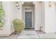 Close up of the home's entry way with a gray front door, exterior lights, and a small landscaped area at 10505 Jeremy Ridge Ave, Las Vegas, NV 89144