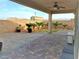 Relaxing covered back patio with desert landscaping offers an inviting outdoor space at 1128 Via Della Curia, Henderson, NV 89011