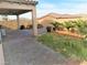 Private backyard boasts a covered patio, manicured lawn, and lush tropical landscaping, perfect for relaxing at 1128 Via Della Curia, Henderson, NV 89011