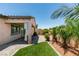 Backyard featuring a covered patio, well-manicured grass area, and decorative palm trees at 1128 Via Della Curia, Henderson, NV 89011