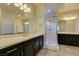 Primary bathroom featuring double sinks, a glass shower, and dark wood cabinets at 1128 Via Della Curia, Henderson, NV 89011
