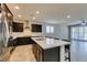 Bright kitchen with stainless steel appliances, quartz countertops, and a spacious island with bar seating at 1128 Via Della Curia, Henderson, NV 89011