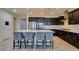 Modern kitchen with a large island, bar seating, stainless steel appliances, and dark cabinets at 1128 Via Della Curia, Henderson, NV 89011