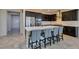 Modern kitchen with a large island, bar seating, stainless steel appliances, and dark cabinets at 1128 Via Della Curia, Henderson, NV 89011