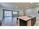 Bright open kitchen with an island, bar seating, and a view into the living area at 1128 Via Della Curia, Henderson, NV 89011