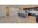 Kitchen with stainless steel appliances, dark cabinetry, an island with seating and light countertops at 1128 Via Della Curia, Henderson, NV 89011