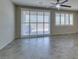 Bright living room features tile flooring, ceiling fan, and sliding glass doors with plantation shutters at 1128 Via Della Curia, Henderson, NV 89011