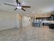 Open-concept living room with tile flooring flowing into kitchen, and a modern ceiling fan at 1128 Via Della Curia, Henderson, NV 89011
