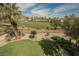 Landscaped backyard featuring synthetic grass, desert landscaping, and golf course views at 11534 Glowing Sunset Ln, Las Vegas, NV 89135