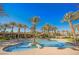 Stunning community pool featuring palm trees, pristine blue water, and inviting lounge areas for relaxation at 11534 Glowing Sunset Ln, Las Vegas, NV 89135