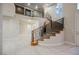 Spacious foyer boasts curved staircase, iron railings, tile floors, and architectural detailing, showcasing an elegant entrance at 11534 Glowing Sunset Ln, Las Vegas, NV 89135