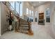 Elegant foyer featuring a curved staircase, marble floors, a modern fireplace, and ample natural light through arched windows at 11534 Glowing Sunset Ln, Las Vegas, NV 89135