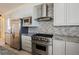Modern kitchen featuring stainless steel appliances, gray-toned cabinets, tile backsplash, and granite countertops at 11534 Glowing Sunset Ln, Las Vegas, NV 89135