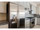 Close-up view of stainless steel refrigerator, microwave, and stove in a kitchen with granite countertops and backsplash at 11534 Glowing Sunset Ln, Las Vegas, NV 89135