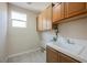 Practical laundry room with tile floor, ample cabinet space, and a utility sink at 11534 Glowing Sunset Ln, Las Vegas, NV 89135