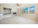 Bright living room with fireplace, built-in shelving, and a serene view of the backyard at 11534 Glowing Sunset Ln, Las Vegas, NV 89135