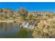 Scenic pond featuring a small waterfall and lush landscaping, complemented by beautiful homes and a golf course at 11534 Glowing Sunset Ln, Las Vegas, NV 89135