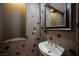 Stylish powder room featuring unique wallpaper and modern sink fixture at 11534 Glowing Sunset Ln, Las Vegas, NV 89135