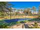 Well-maintained tennis court with a vibrant blue surface, surrounded by lush greenery and mountain views at 11534 Glowing Sunset Ln, Las Vegas, NV 89135
