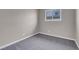 Neutral bedroom features gray carpet, a window with security bars, and base trim at 1189 Blankenship Ave, Las Vegas, NV 89106