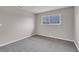 Cozy bedroom with neutral walls, gray carpet, and a barred window at 1189 Blankenship Ave, Las Vegas, NV 89106