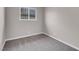 Neutral bedroom features gray carpet, a window with security bars, and base trim at 1189 Blankenship Ave, Las Vegas, NV 89106