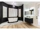 Modern bathroom with a freestanding tub, sleek black vanity, and elegant chandelier lighting at 1350 Rossini St, Henderson, NV 89052