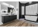 Modern bathroom with a freestanding tub, sleek black vanity, and elegant chandelier lighting at 1350 Rossini St, Henderson, NV 89052