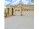 A neutral-toned, single-story home features a three-car garage and well-kept desert landscaping, reflecting a simple elegance at 1350 Rossini St, Henderson, NV 89052