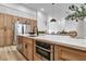 Close up of kitchen island with sink, oven, stainless steel dishwasher, and wooden cabinets at 1350 Rossini St, Henderson, NV 89052