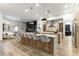 Bright, open kitchen featuring a large island with seating, pendant lighting, and views of the living area at 1350 Rossini St, Henderson, NV 89052
