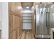 View of walk-in pantry next to stainless steel refrigerator and wooden kitchen cabinets at 1350 Rossini St, Henderson, NV 89052