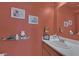 Cozy half bathroom with a white sink, wood cabinets, and a warm, inviting ambiance at 1453 Blisworth Ct # 102, Las Vegas, NV 89102