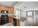 Functional kitchen featuring wooden cabinets, granite countertops, and black appliances, seamlessly connected to the dining area at 1531 Evening Spirit Ave, Las Vegas, NV 89183
