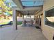 Inviting covered back patio with stone flooring, ceiling fan, and outdoor seating area at 2065 Pinion Springs Dr, Henderson, NV 89074