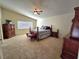 Spacious carpeted bedroom with ceiling fan, window, and beautiful furnishings at 2065 Pinion Springs Dr, Henderson, NV 89074